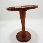 Round solid wood coffee table with tapered pedestal and natural finish