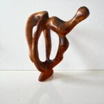 Contemporary wooden sculpture with flowing lines and warm grain
