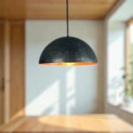 Copper Dome Lamp hanging in a modern interior, featuring a stylish black and orange design.