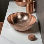 Coppera Studio hammered copper vessel sink with a polished rim, perfect for a rustic or modern bathroom.