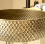 Oxidized copper vessel sink with a textured hammered design showcasing its unique craftsmanship.